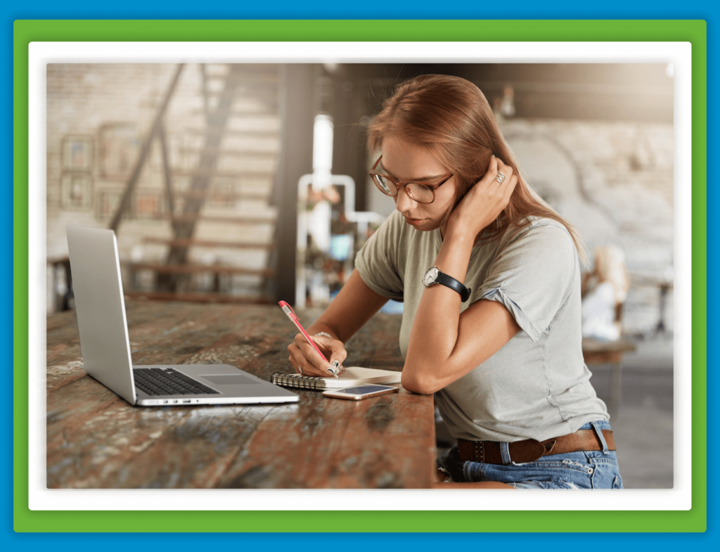 A woman studying with a laptop and notebook.