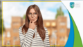 A thoughtful woman in glasses in front of a blurred building.