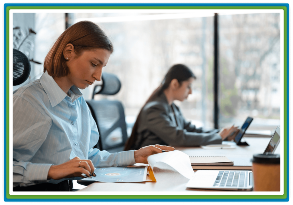 Two women working at desks in a modern office.
